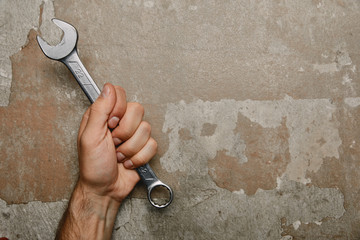 Wall Mural - Partial view of man holding wrench on old background