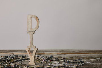 Wall Mural - Close up of diy arranged vertically sign and nails on wooden table on grey background