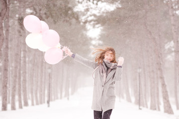 Wall Mural - Happy teenage girl holding balloons running outdoors. Winter season.