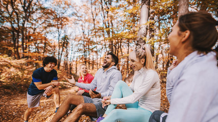 Wall Mural - Group of runners sitting and chatting after running.