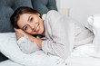 © LIGHTFIELD STUDIOS - smiling girl in pajamas resting in bed