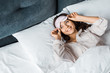 smiling girl in sleeping mask waking up in bed in the morning