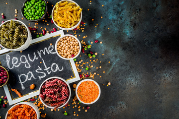 Wall Mural - Trend healthy food, vegan diet concept. Multi colored legume pasta with raw beans. Beans, chickpeas, green peas, lentils. Copy space top view