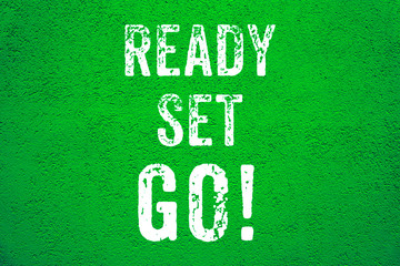 Ready Set Go! white words text on green grungy stucco cement wall background motivational message banner.