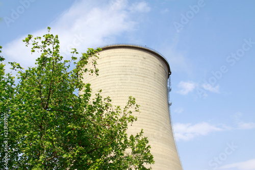 Fotografía heavy industrial water cooling tower and the green tree