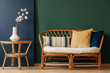 © Photographee.eu - Flowers on natural table next to sofa with cushions in green and blue living room interior. Real photo
