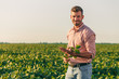 © Zoran Zeremski - Portrait of young farmer standing in filed examining soybean corp.