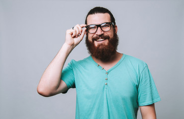 Wall Mural - Portrait of cheerful bearded man wearing eyeglasses and smiling