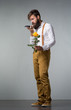 A man with a beard holds a yellow rose
