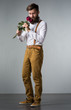 A man with a beard holds with a bouquet of roses