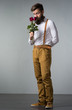 A man with a beard holds with a bouquet of roses