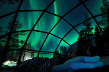 CLOSE UP Young Caucasian Tourist Couple Observing The Night Sky From A Cool Glass House In The Scandinavian Wilderness. Girlfriend And Boyfriend Enjoying A Romantic Evening In A Cool Glassy Igloo.