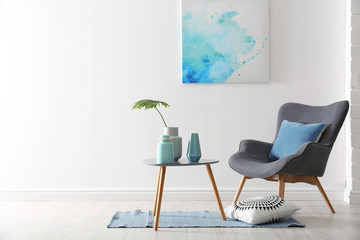 Poster - living room interior with vases on table and armchair near white wall. space for text