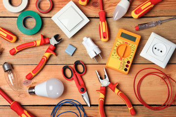 Flat lay composition with electrician's tools on wooden background