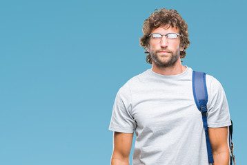 Poster - Handsome hispanic student man wearing backpack and glasses over isolated background with serious expression on face. Simple and natural looking at the camera.