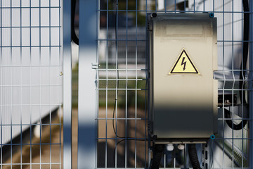 Gray hinged power supply, electric flap. Danger sign with dangerous voltage