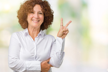 Beautiful middle ager senior businees woman over isolated background smiling with happy face winking at the camera doing victory sign. Number two.