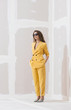 © Stocksy - Young female /fashion model in abstract white space with yellow outfit.