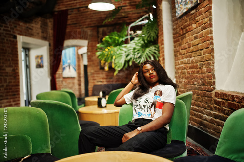 Stylish African American Woman In Printed T Shirt Sitting On