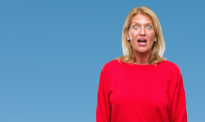 Canvas Print - Middle age blonde woman over isolated background afraid and shocked with surprise expression, fear and excited face.