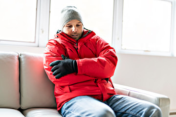 A Man With Warm Clothing Feeling The Cold Inside House on the sofa