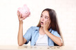© 5second - Young girl with pink piggybank and coins sitting at table