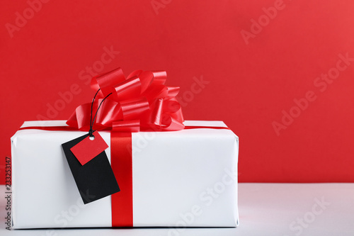Fotografía Black sale tag with gift box on red background