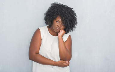 Sticker - Young african american woman over grey grunge wall thinking looking tired and bored with depression problems with crossed arms.