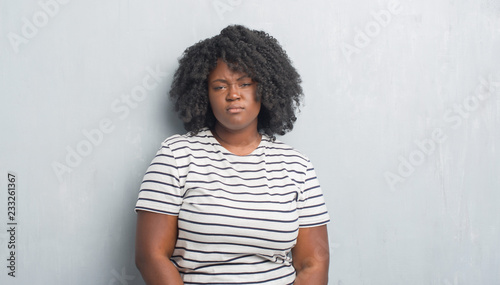 Young African American Plus Size Woman Over Grey Grunge Wall With