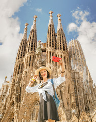 barcelona, spain - 11 july 2018: young asian woman making selfie photo on her smartphone in front of