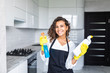 © F8  \ Suport Ukraine - Young latin woman with bottle of detergent in kitchen