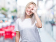 © Krakenimages.com - Young blonde woman over isolated background doing ok gesture with hand smiling, eye looking through fingers with happy face.