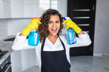 Wall Mural - Young happy latin woman is having fun while doing cleaning at home.