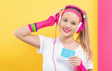 Wall Mural - Woman in 1980's fashion holding a cassette tape on a split yellow and pink background