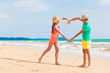 © el.rudakova - happy young couple in bright clothes making heart shape with their hands by the beach. Khao Lak, Thailand