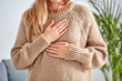 © astrosystem - Young woman with heart problem holding chest.