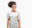 © Krakenimages.com - Young afro american woman wearing glasses over isolated background looking away to side with smile on face, natural expression. Laughing confident.