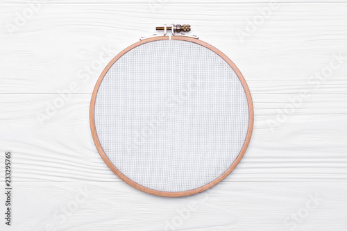 Fotografía Tools for cross stitch. A hoop for embroidery and canvas on white