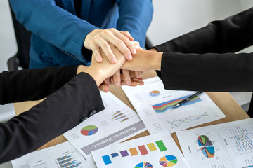 Wall Mural - close up hand of business partnership people stacking hands finishing up meeting showing unity over office desk  , business teamwork concept