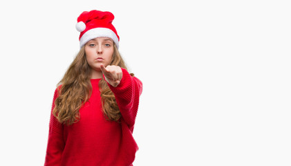 Poster - Young blonde woman wearing santa claus hat pointing with finger to the camera and to you, hand sign, positive and confident gesture from the front