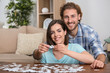 © Pixel-Shot - Young couple doing jigsaw puzzle at home