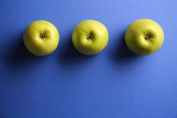 Ripe tasty apples on color background, top view