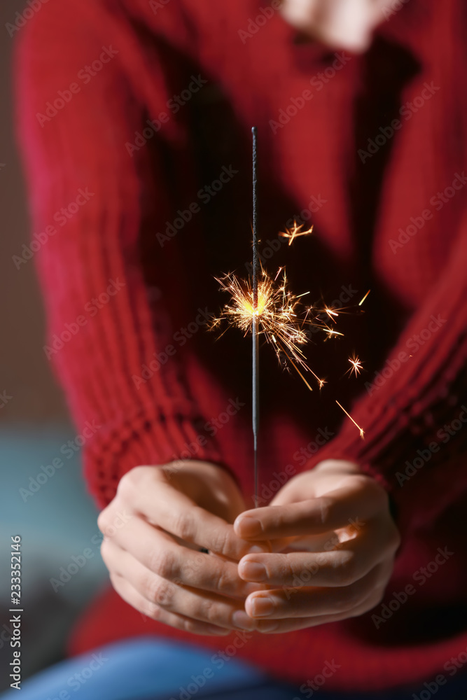Woman with Christmas sparkler, closeup