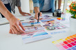 © MIND AND I - Asian advertising designer creative start-up team discussing ideas in office.