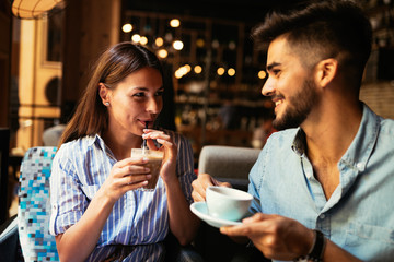 Wall Mural - Young attractive couple on date in coffee shop