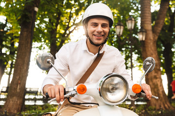 Poster - Excited young businessman riding on a motorbike