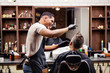 © Halfpoint - Rear view of man client visiting haidresser and hairstylist in barber shop.