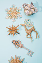 Wall Mural - Golden beautiful sparkling christmas decoration on pastel blue background. Place for text. Festive concept.