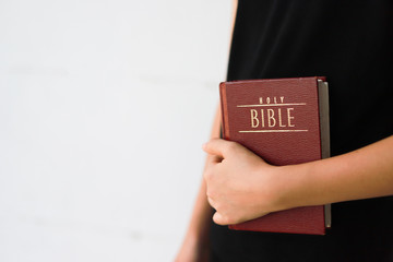 Wall Mural - A girl is holding the bible book.