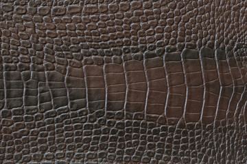 Texture of crocodile artificial leather of brown color.